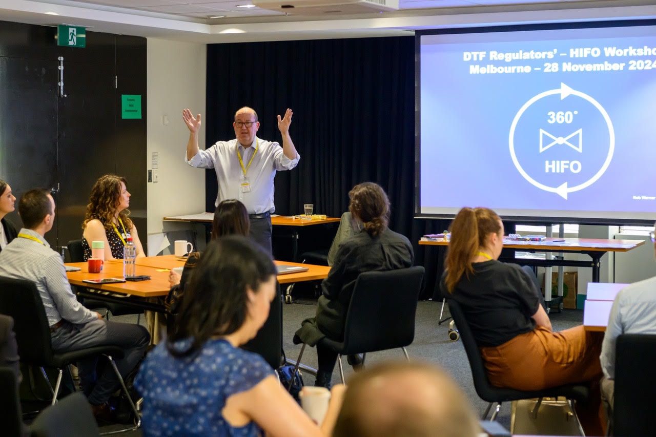 Rob Warner leading a regulators workshop with participants seated at tables